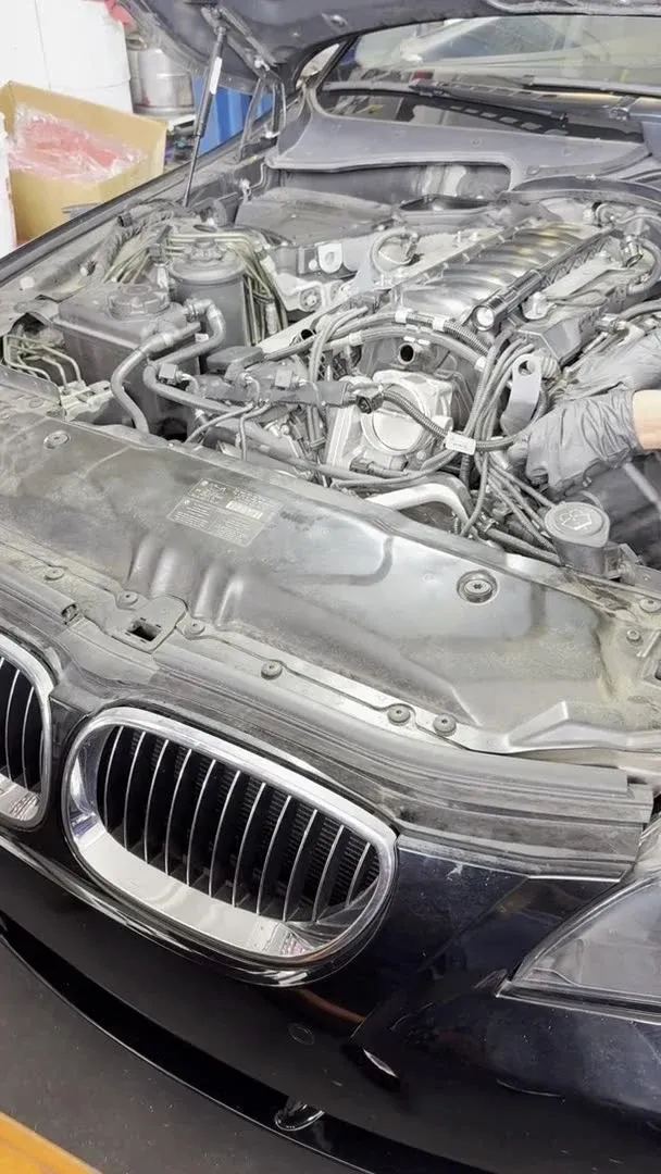 BMW 550i with hood up showing the kidney grille and N62 4.8L V8 engine bay at Beacon Auto Care San Mateo