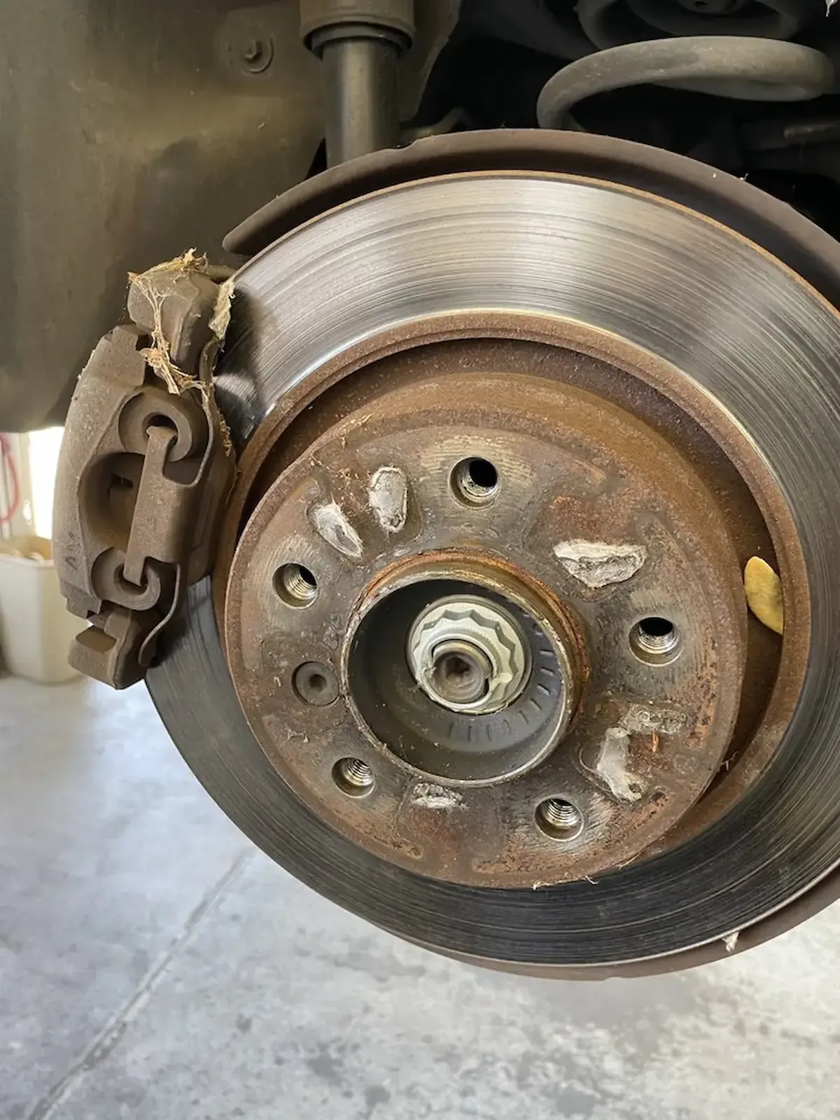 Worn brake rotor and caliper close-up at Beacon Auto Care San Mateo